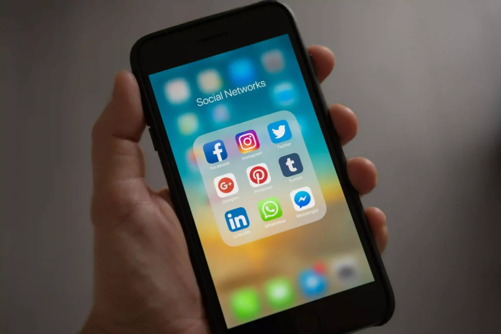 image of a phone with social media logos in a female voice over artist in kerala's hand.