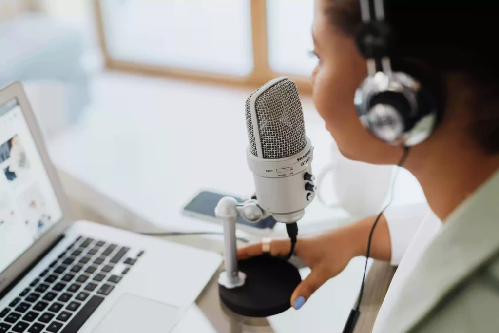 a female voice over artist in kerala recording by sitting in front of the mic.